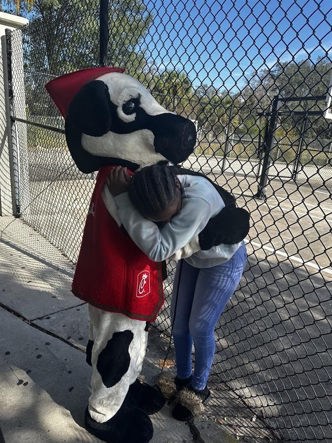 Student hugging Chick-fil-a cow