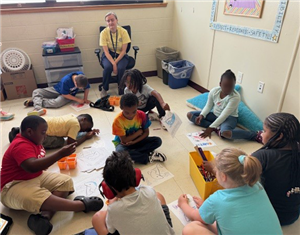 students sitting on floor designing posters