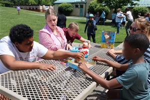Vanguard students and staff playing a board game