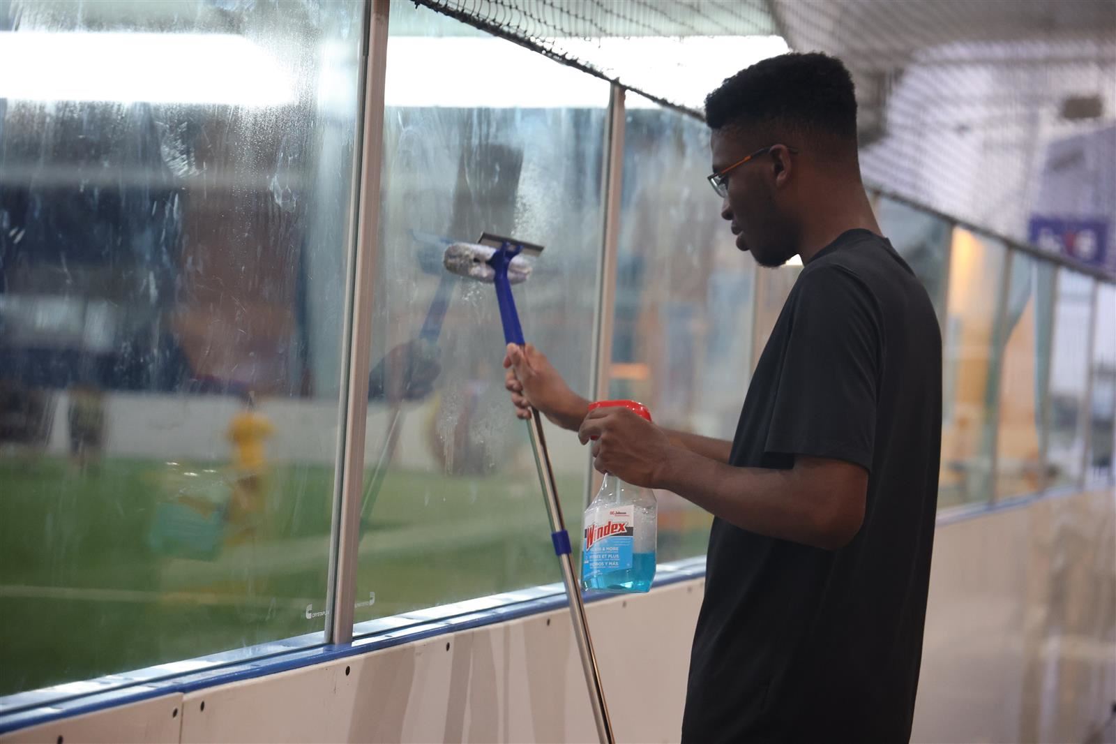 student cleaning window