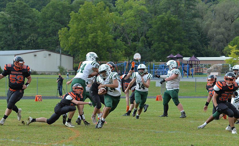 Football Weedsport varsity football player runs with the ball