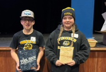 A boy and girl holding plaques