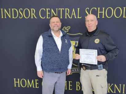 Pete Nowacki and Jim Surdoval standing in front of a banner