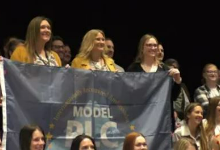 Three women holding a flag