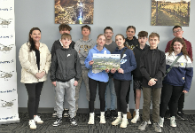 A woman standing with middle school students