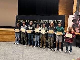 High school students in front of a banner