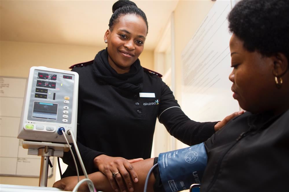 Nursing assistants taking blood pressure.