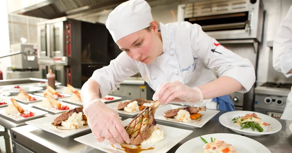 Student plating food to serve to customers.