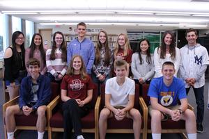 thirteen students, male and female, pose for a photo