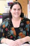 a woman in a flowered shirt is smiling