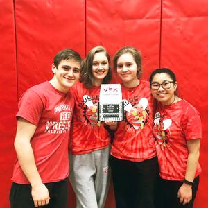 Three girls and one boy hold a trophy