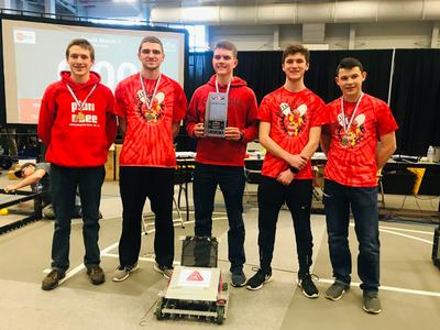 five boys stand together and one holds a trophy