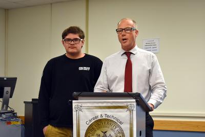 a teenager boy stands with a teacher