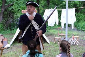 a man is dressed in the clothes of a colonial soldier