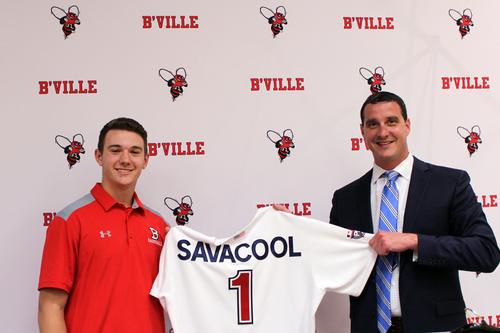 a teenage boy and a man hold up a jersey