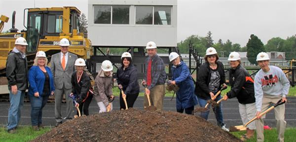 MACS BOE digs in a pile of dirt with shovels for the groundbreaking of the Stadium Project 