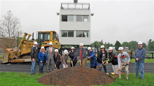 MACS BOE digs in a pile of dirt with shovels for the opening of the stadium project 