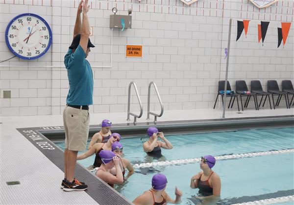  Coach Shawn Parkhurst, left, provides instruction during a girls varsity swim meet in fall 2019.