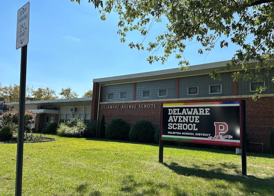 DAS view from door 1 2023 trees, lawn mid-century building and ugly sign