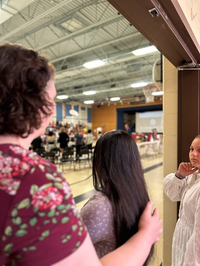 mrs. allen directs students into the gym for the ceremony