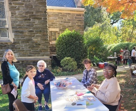 children & senior citizens around the table making sand art at fall festival