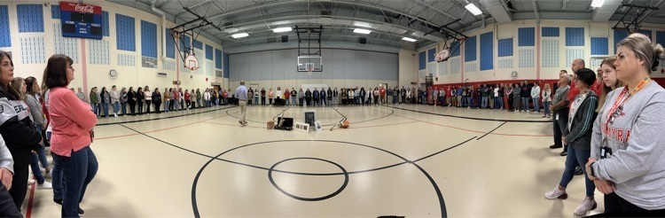 our District Circle of Support: faculty & staff from all buildings standing in a circle in css gym