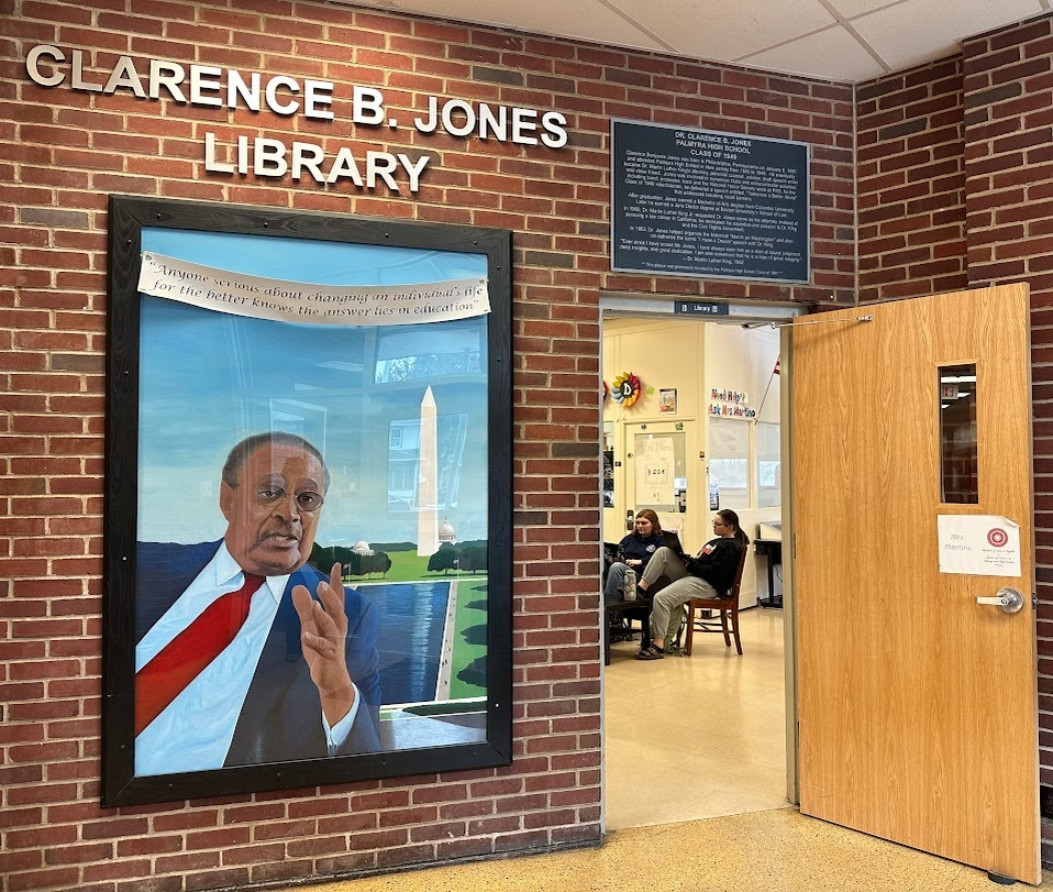 photo of portrait of Clarence B Jones '49 with door open into library with students inside