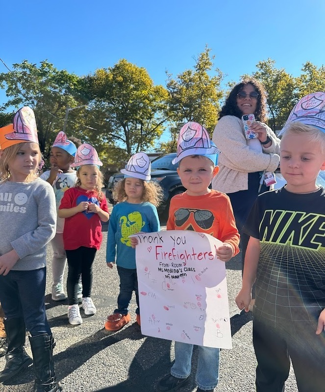 student holding a thank you sign for the fire assembly with his classmates