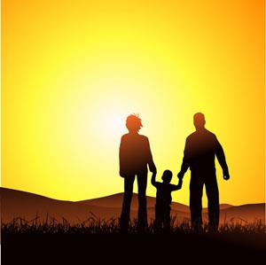 Two parents walking with a child at sunset holding hands. 