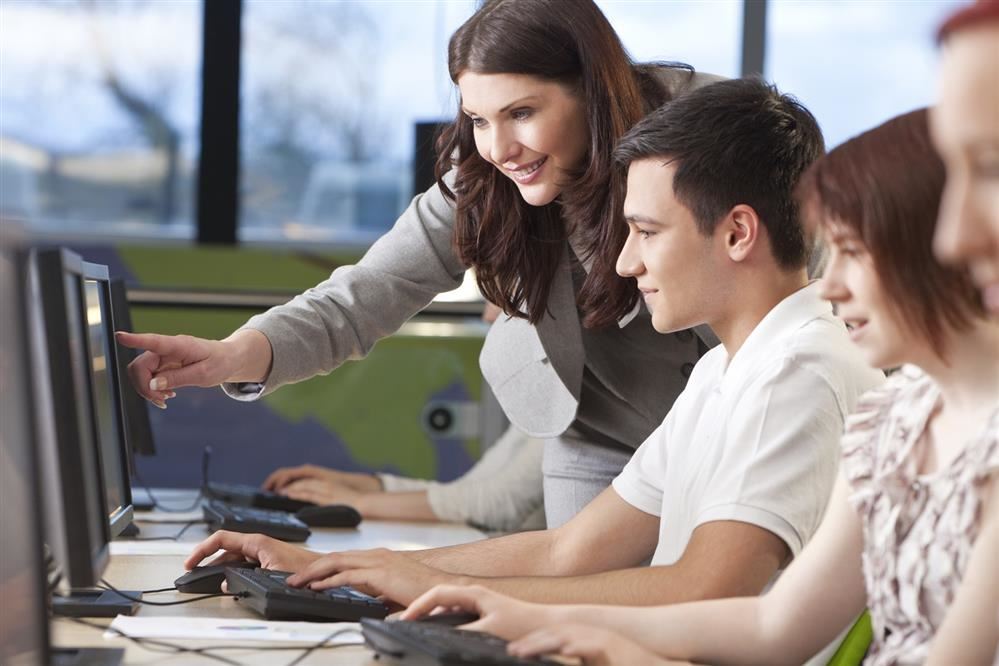 Instructor helping students at computer